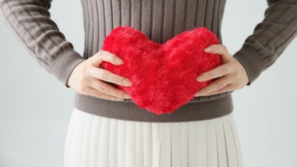 ハートのクッションを持っている女性